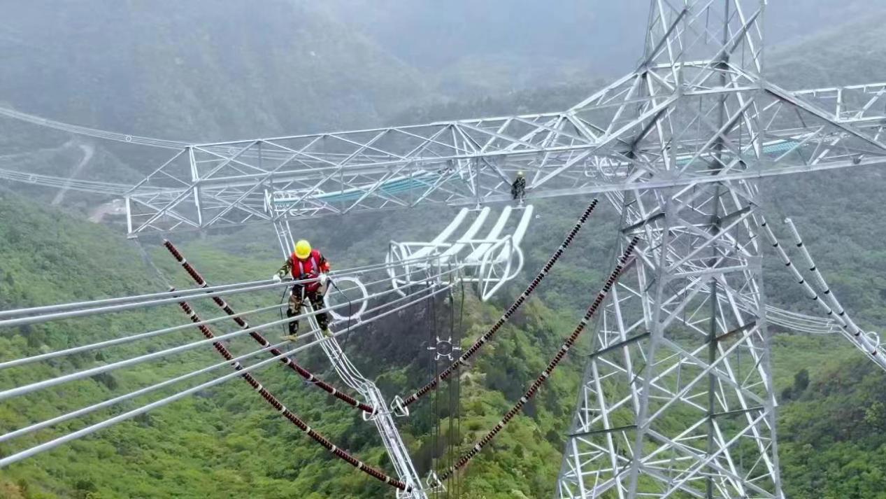 崇山峻岭间，特战班成员在高120米、直径11公分左右的导线上作业